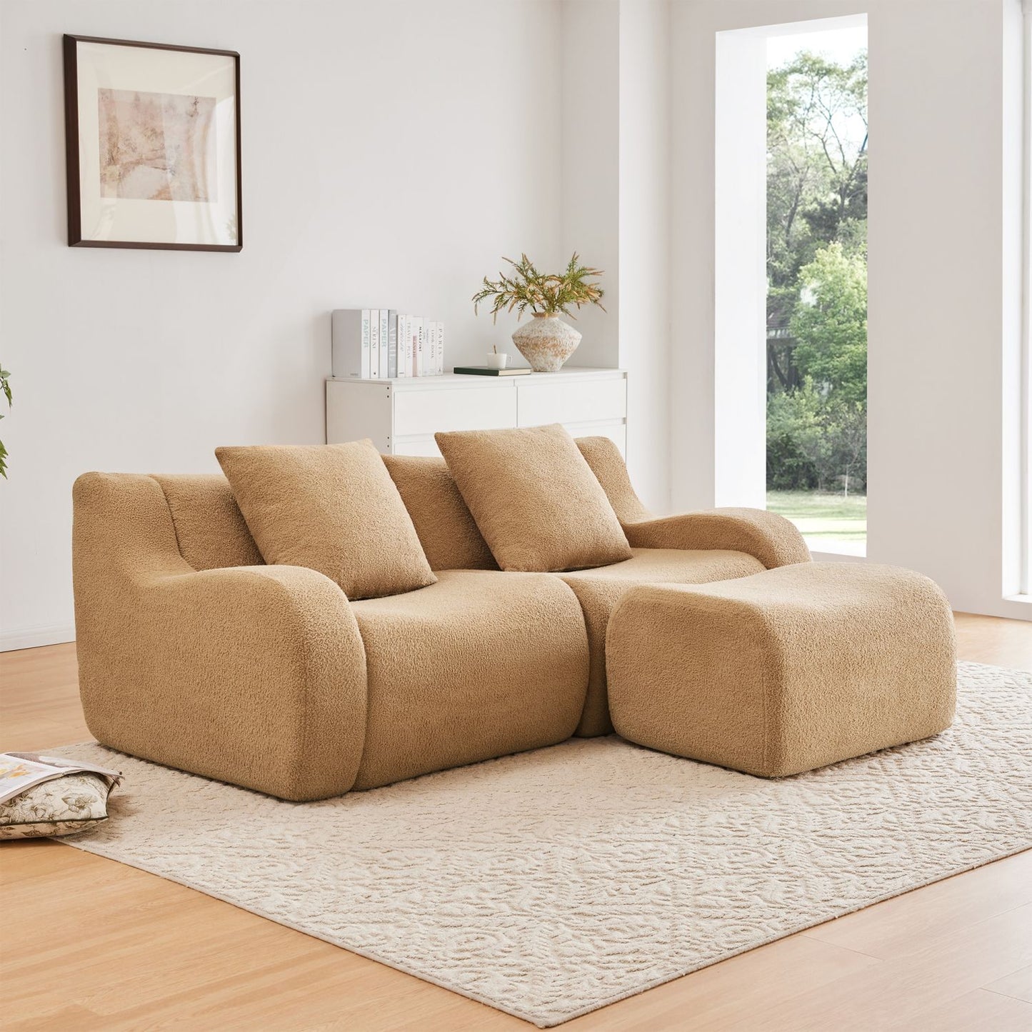 Beige sectional sofa in a living room with a large window and decorative items.