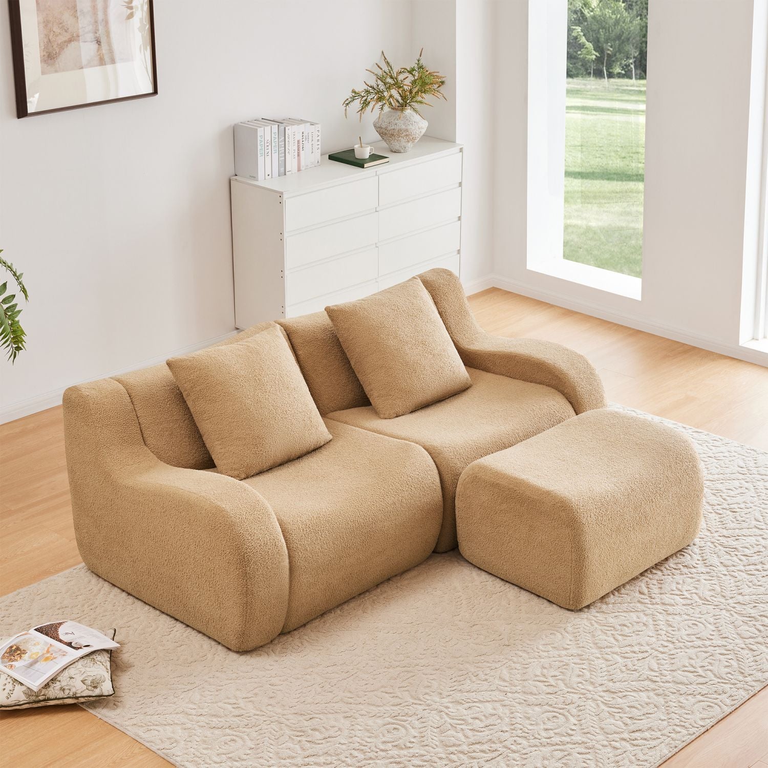Beige sectional sofa in a modern living room with large windows.